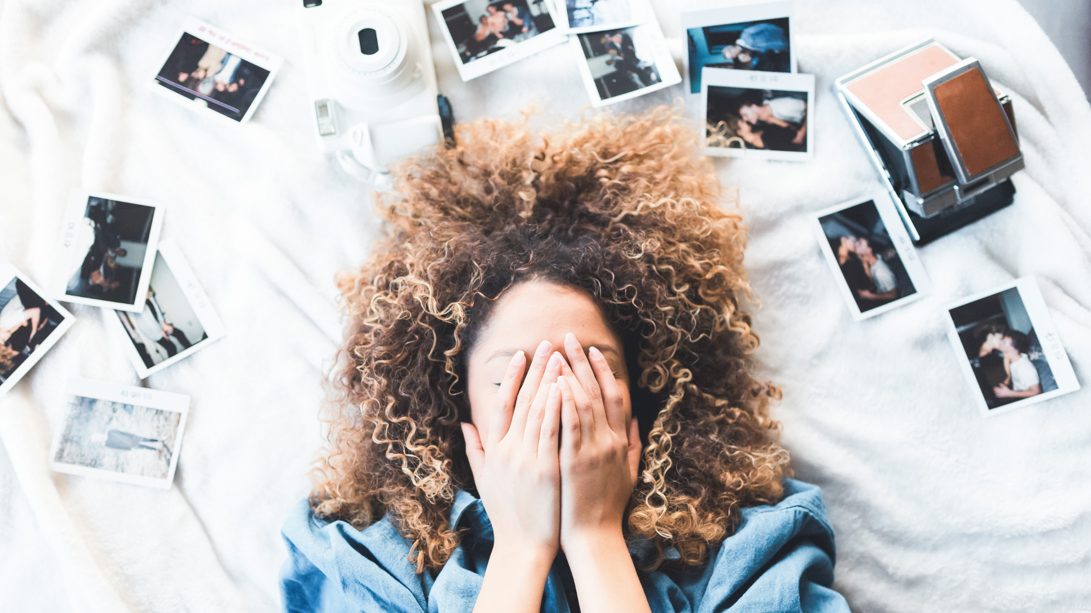 Woman with her hands over her face feeling insecure with photos scattered around her head